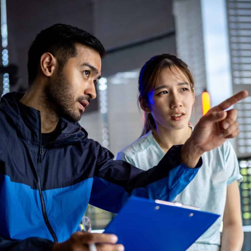 Asian man and woman working out, one is a trainer, the other is
